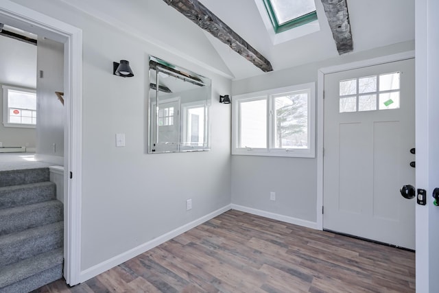 entryway featuring vaulted ceiling with skylight, hardwood / wood-style floors, and a baseboard heating unit