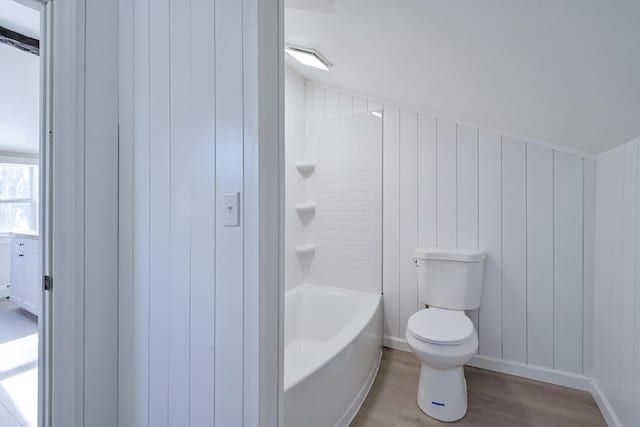 bathroom featuring  shower combination, toilet, and hardwood / wood-style floors