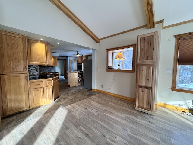 kitchen with tasteful backsplash, light wood-style flooring, a wealth of natural light, and freestanding refrigerator