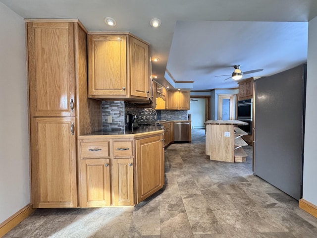 kitchen with a center island, backsplash, appliances with stainless steel finishes, ceiling fan, and a sink