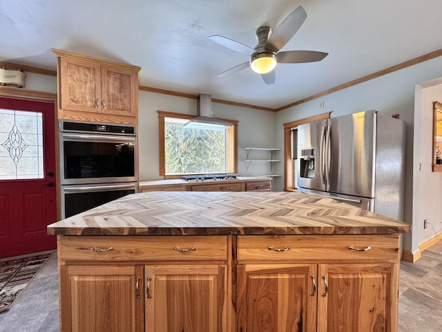 kitchen with a ceiling fan, wall chimney exhaust hood, butcher block counters, appliances with stainless steel finishes, and ornamental molding