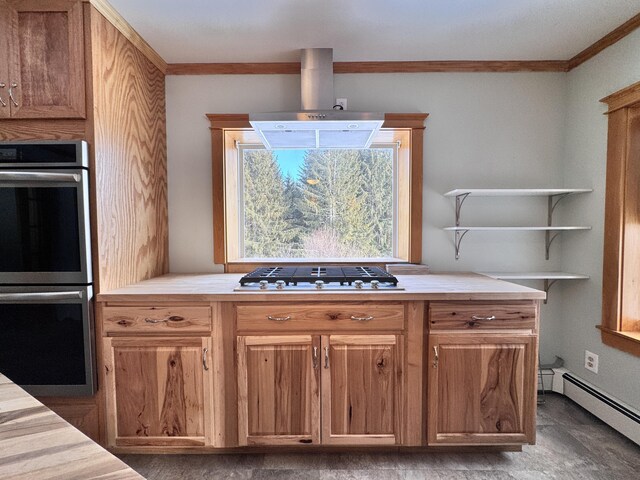 kitchen with ornamental molding, double oven, baseboard heating, wall chimney range hood, and gas stovetop