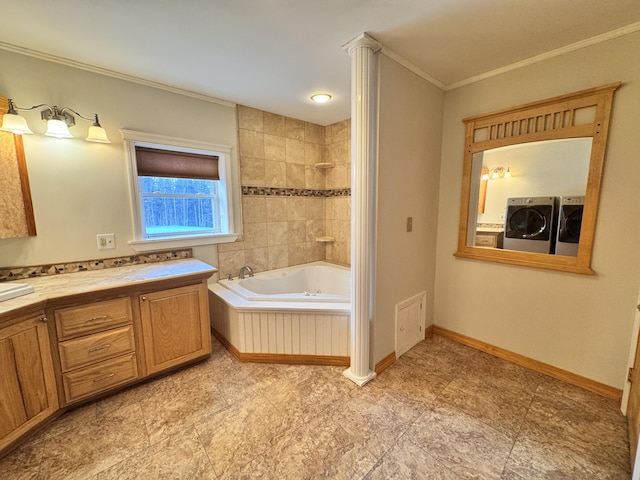 bathroom with visible vents, baseboards, crown molding, vanity, and washing machine and dryer