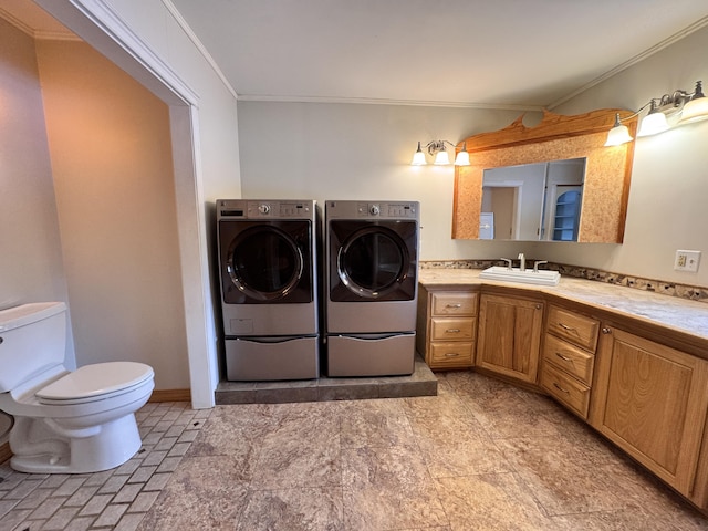 bathroom with baseboards, toilet, ornamental molding, washer and dryer, and vanity