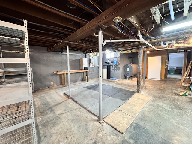 unfinished basement with electric panel and heating fuel