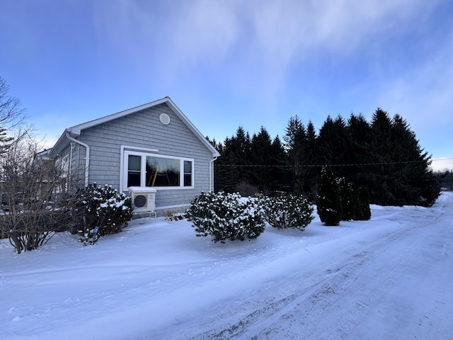 snow covered property with ac unit