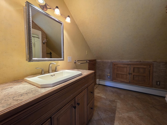 bathroom featuring lofted ceiling, tile patterned flooring, baseboard heating, and vanity