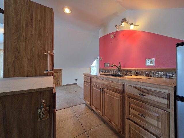 kitchen featuring light carpet, light tile patterned flooring, vaulted ceiling, a sink, and recessed lighting