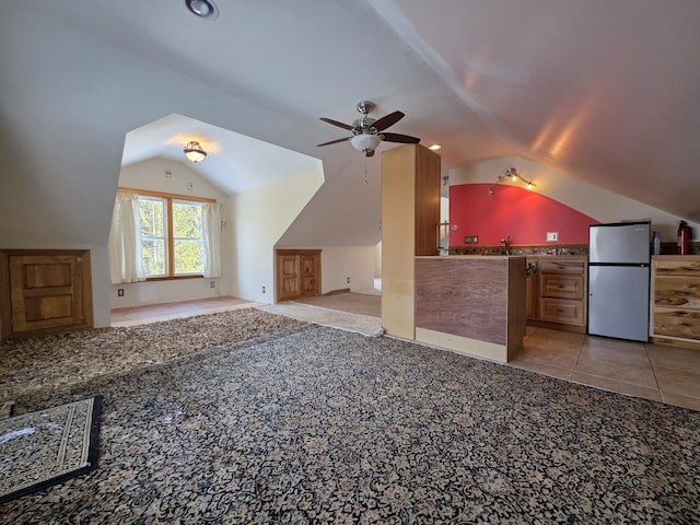 bonus room featuring light carpet, a ceiling fan, lofted ceiling, a sink, and light tile patterned flooring