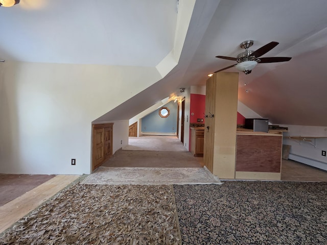 additional living space with ceiling fan, a baseboard heating unit, and vaulted ceiling