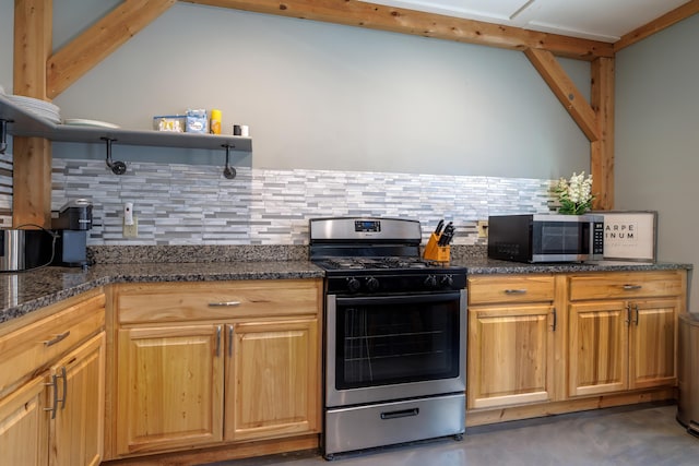 kitchen featuring appliances with stainless steel finishes, decorative backsplash, and dark stone countertops