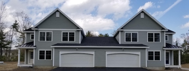 view of front of home with a standing seam roof, driveway, and metal roof