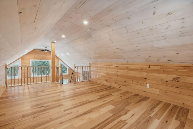 bonus room with wood-type flooring, lofted ceiling, wooden ceiling, and wood walls