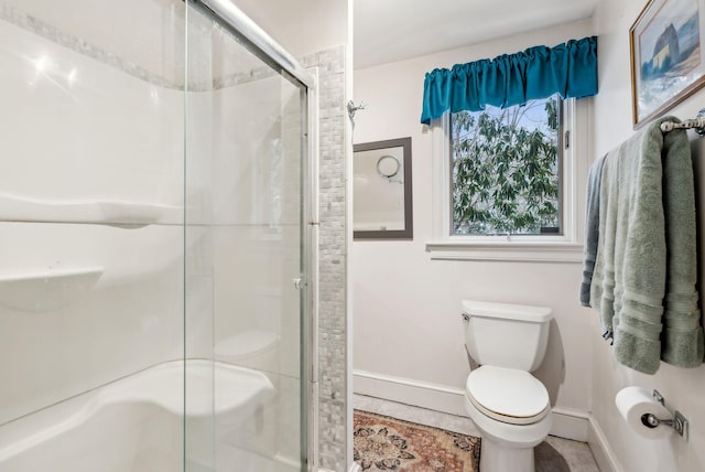 bathroom featuring toilet, a shower with shower door, and tile patterned flooring