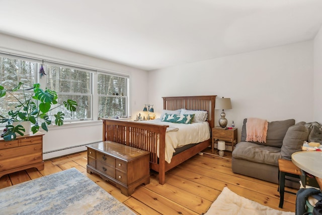 bedroom with a baseboard radiator and light hardwood / wood-style floors