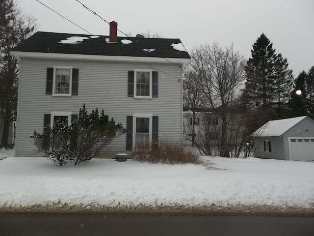 view of front facade featuring a garage and an outbuilding