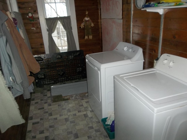 laundry area featuring washing machine and dryer and wood walls