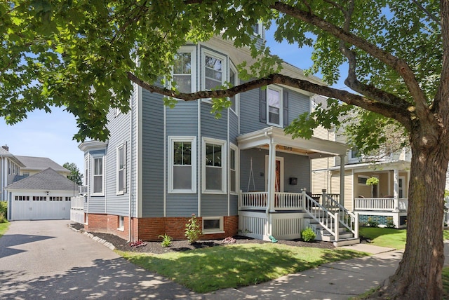 view of front of property with a garage, covered porch, and an outdoor structure