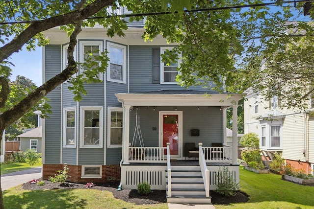 view of front of property with covered porch and a front yard