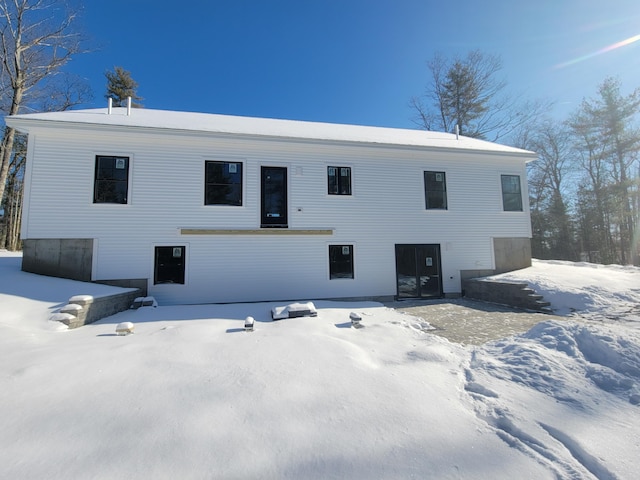 view of snow covered rear of property