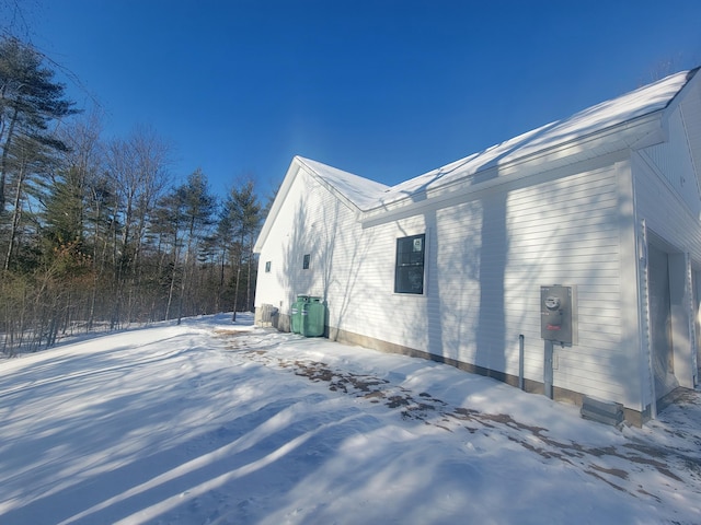 snow covered property with a garage