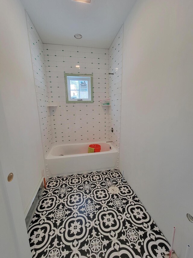 bathroom with tile patterned flooring and a bath