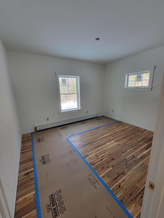 spare room with hardwood / wood-style flooring and baseboard heating