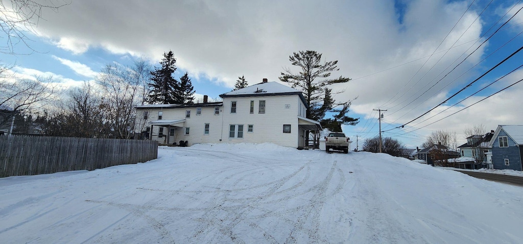 view of snow covered back of property