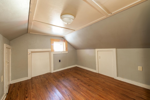 additional living space with hardwood / wood-style flooring and lofted ceiling