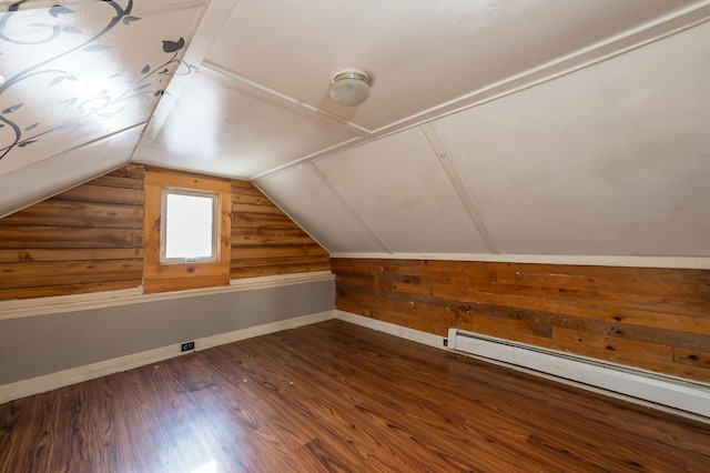 additional living space with dark wood-type flooring, a baseboard radiator, and lofted ceiling