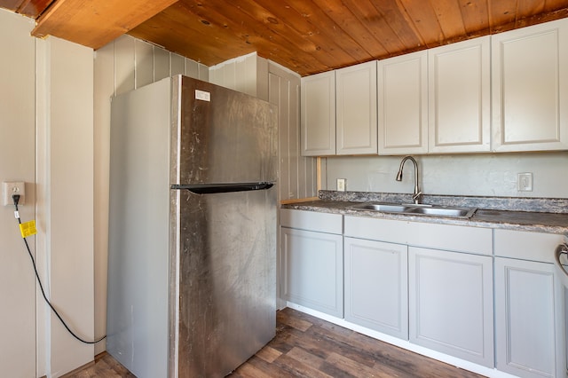 kitchen featuring stainless steel refrigerator, dark hardwood / wood-style flooring, sink, and white cabinets