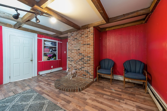 sitting room featuring beamed ceiling, a baseboard radiator, and hardwood / wood-style flooring