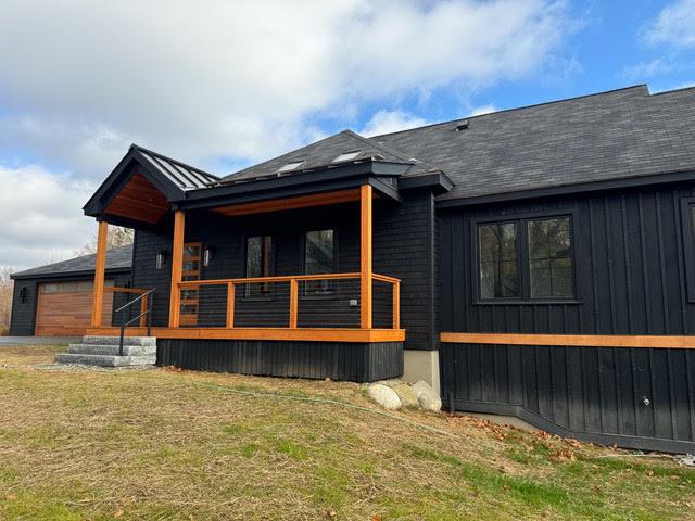 back of house featuring a garage and a lawn