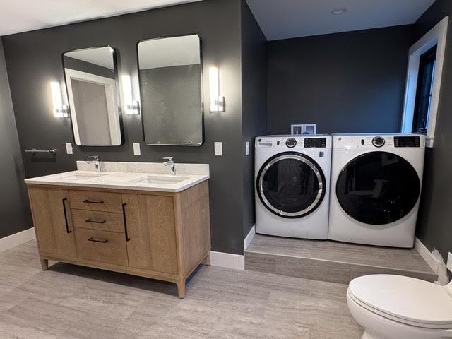 bathroom featuring independent washer and dryer, wood-type flooring, toilet, and vanity