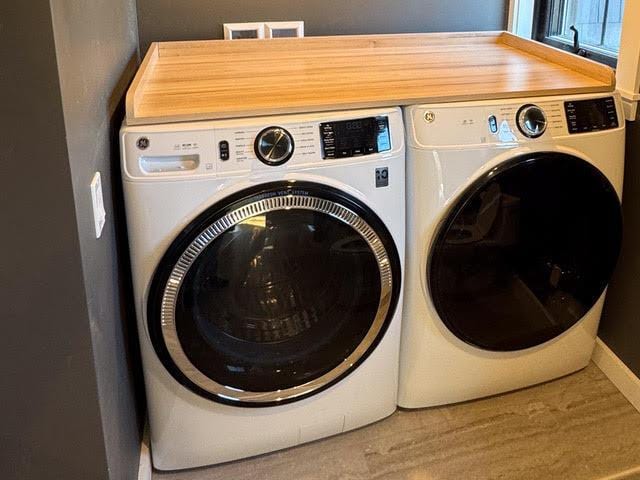 laundry room featuring hardwood / wood-style flooring and separate washer and dryer