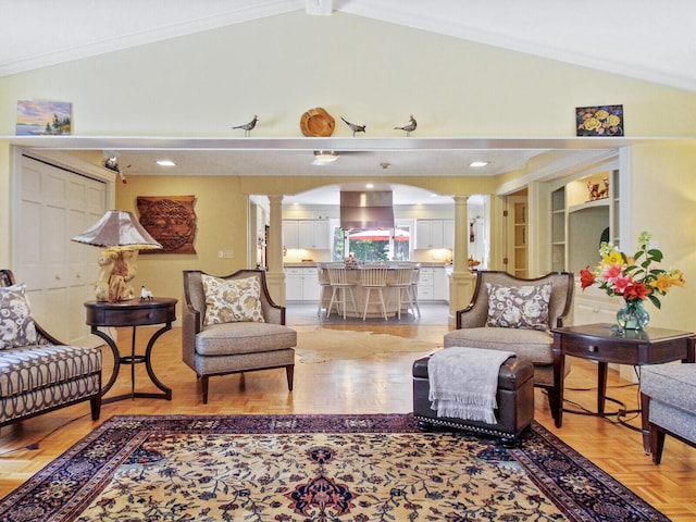 living room featuring crown molding, lofted ceiling with beams, and ornate columns