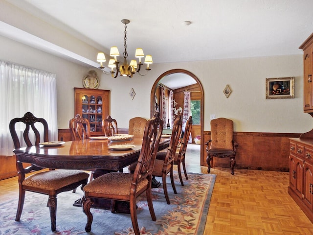 dining area featuring light parquet floors and a notable chandelier