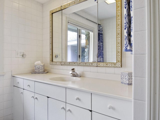 bathroom featuring vanity and tile walls