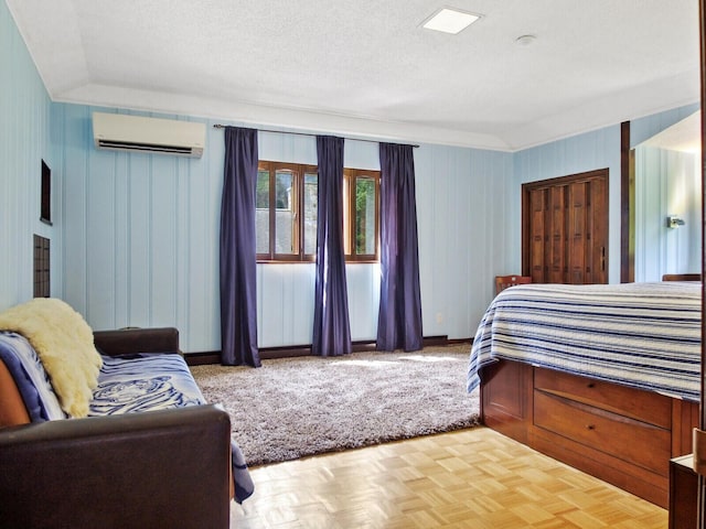 bedroom with a textured ceiling, parquet flooring, and a wall mounted AC