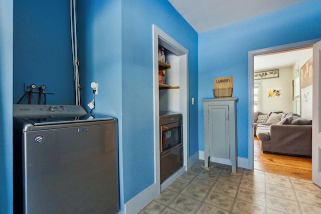 clothes washing area featuring washer / dryer and built in shelves