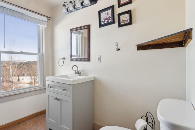 bathroom with tile patterned floors, plenty of natural light, toilet, and vanity