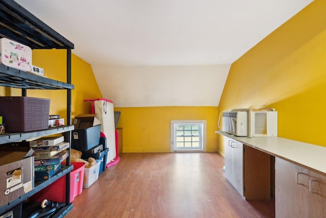 additional living space featuring lofted ceiling and light hardwood / wood-style flooring