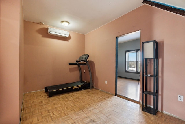 workout room featuring light parquet flooring and a wall unit AC