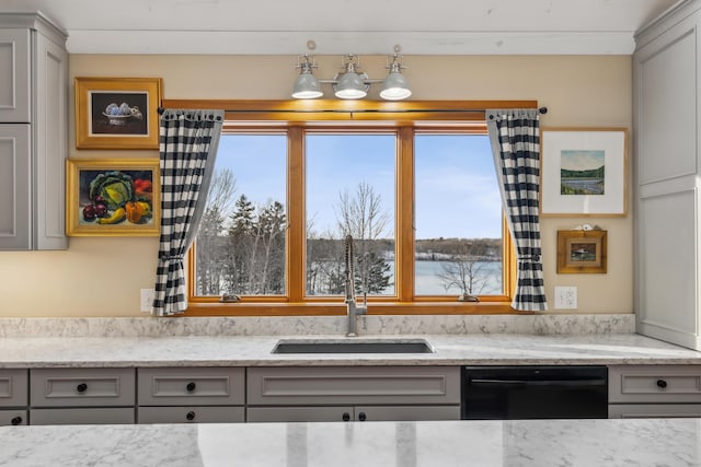 kitchen featuring light stone counters, black dishwasher, sink, and gray cabinetry