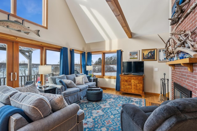 living room with hardwood / wood-style flooring, a towering ceiling, a brick fireplace, and beamed ceiling