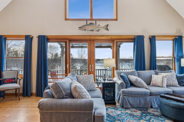 living room featuring high vaulted ceiling and light hardwood / wood-style floors