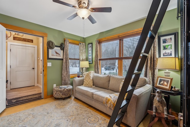 living area with wood-type flooring and ceiling fan