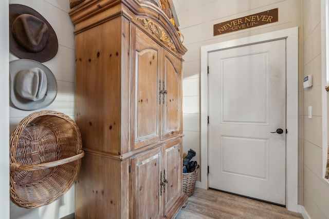 interior space with light hardwood / wood-style floors and wood walls