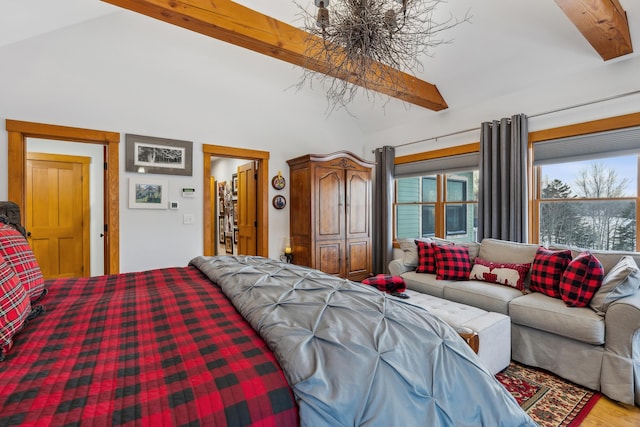 bedroom with lofted ceiling with beams and hardwood / wood-style floors