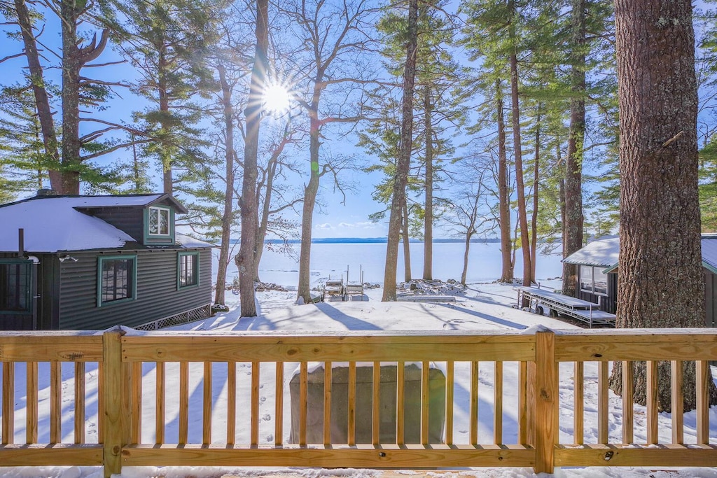 snow covered deck featuring a water view